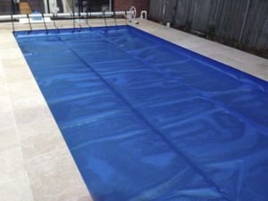 Solar blanket with C-Frame roller on rectangular pool